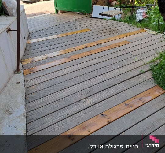 דק עץ עם לוחות עץ בהירים בגינה